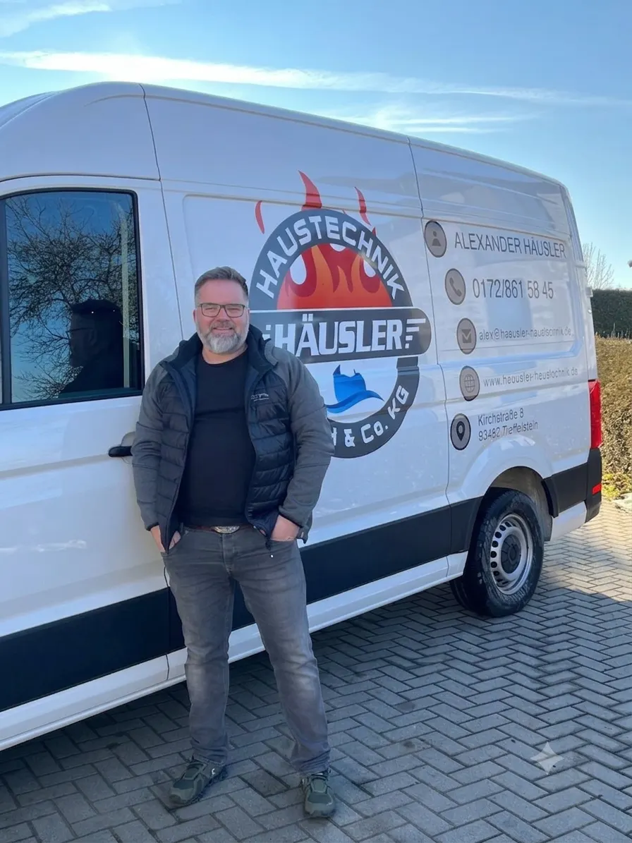 Alexander Häusler, Geschäftsführer der Häusler Haustechnik GmbH & Co. KG, vor einem Servicewagen mit Firmenlogo.