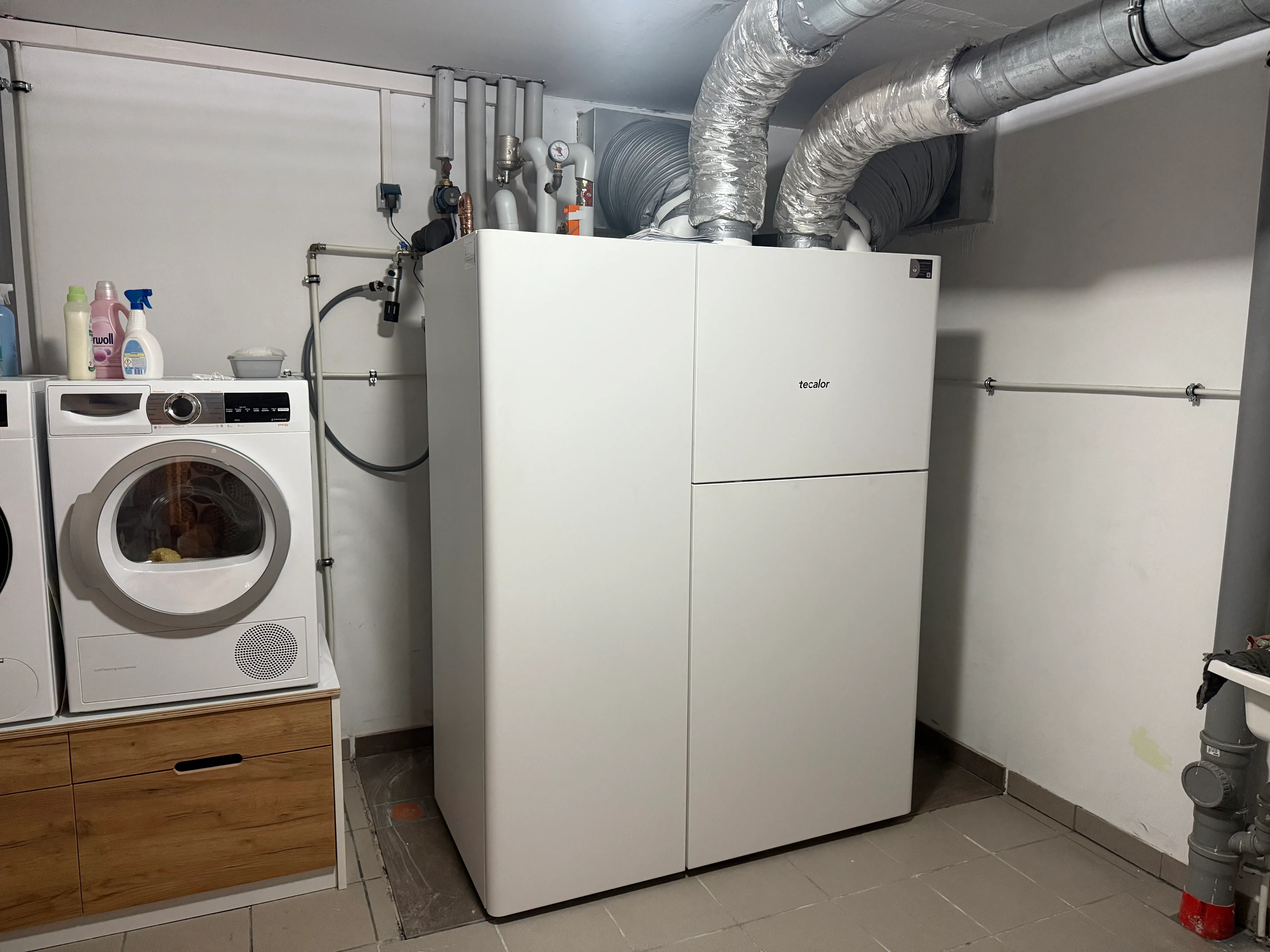 Eingebaute Tecalor-Wärmepumpe mit Lüftungskanälen im Technikraum eines Wohnhauses.