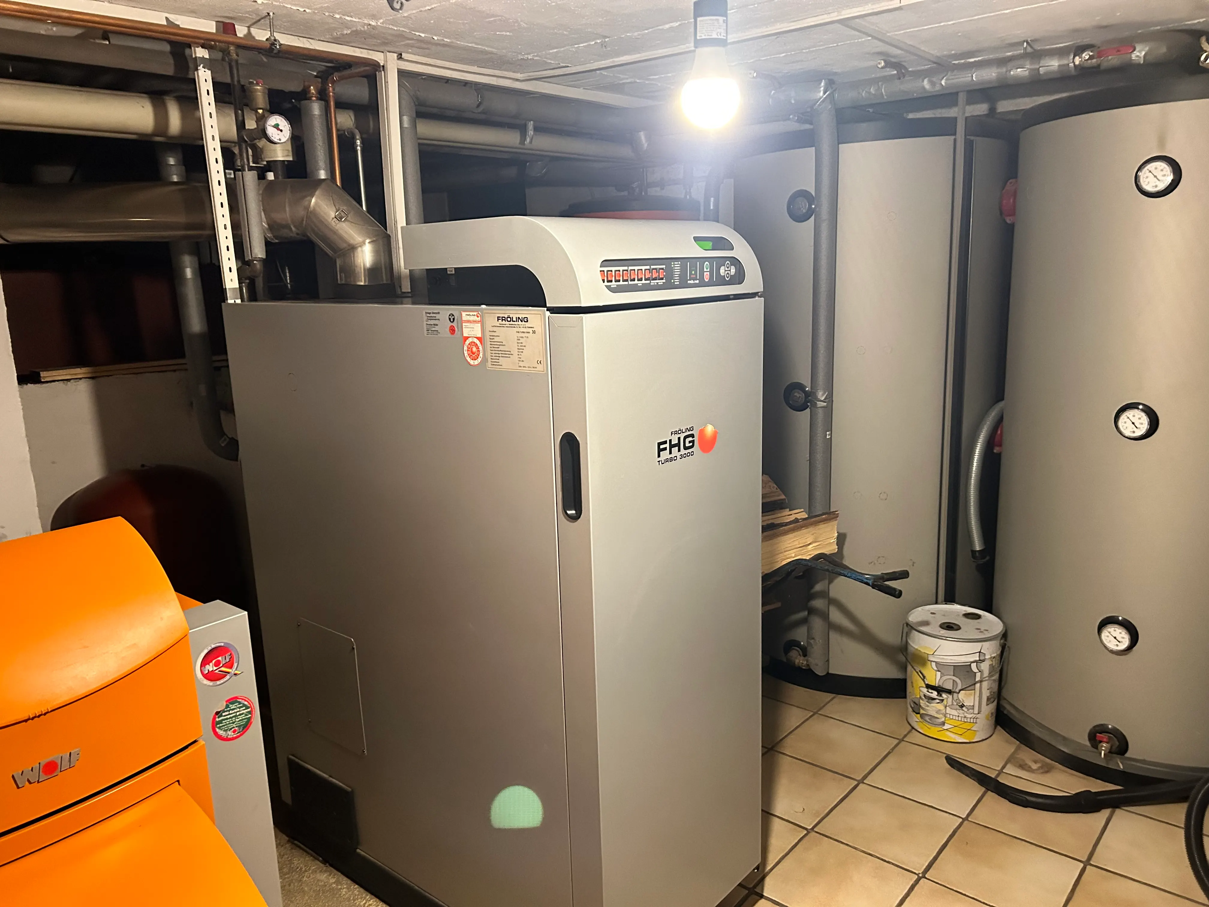 Heizraum mit Fröling FHG TURBO 3000 Holzvergaserkessel, weiterem Heizgerät und Pufferspeicher — eigene Installation von Häusler Haustechnik.